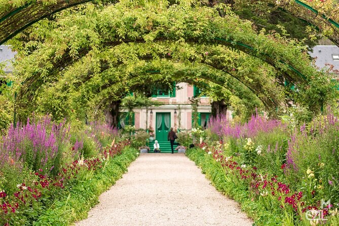 Flower-covered arches leading down the path towards the house